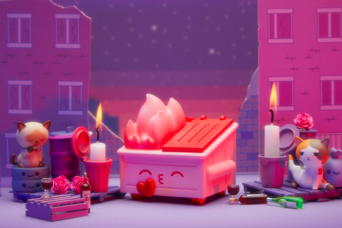 The Kiss Me, I'm Trash Dumpster Fire figure pictured in a romantic setting with trash kitty figures and candles