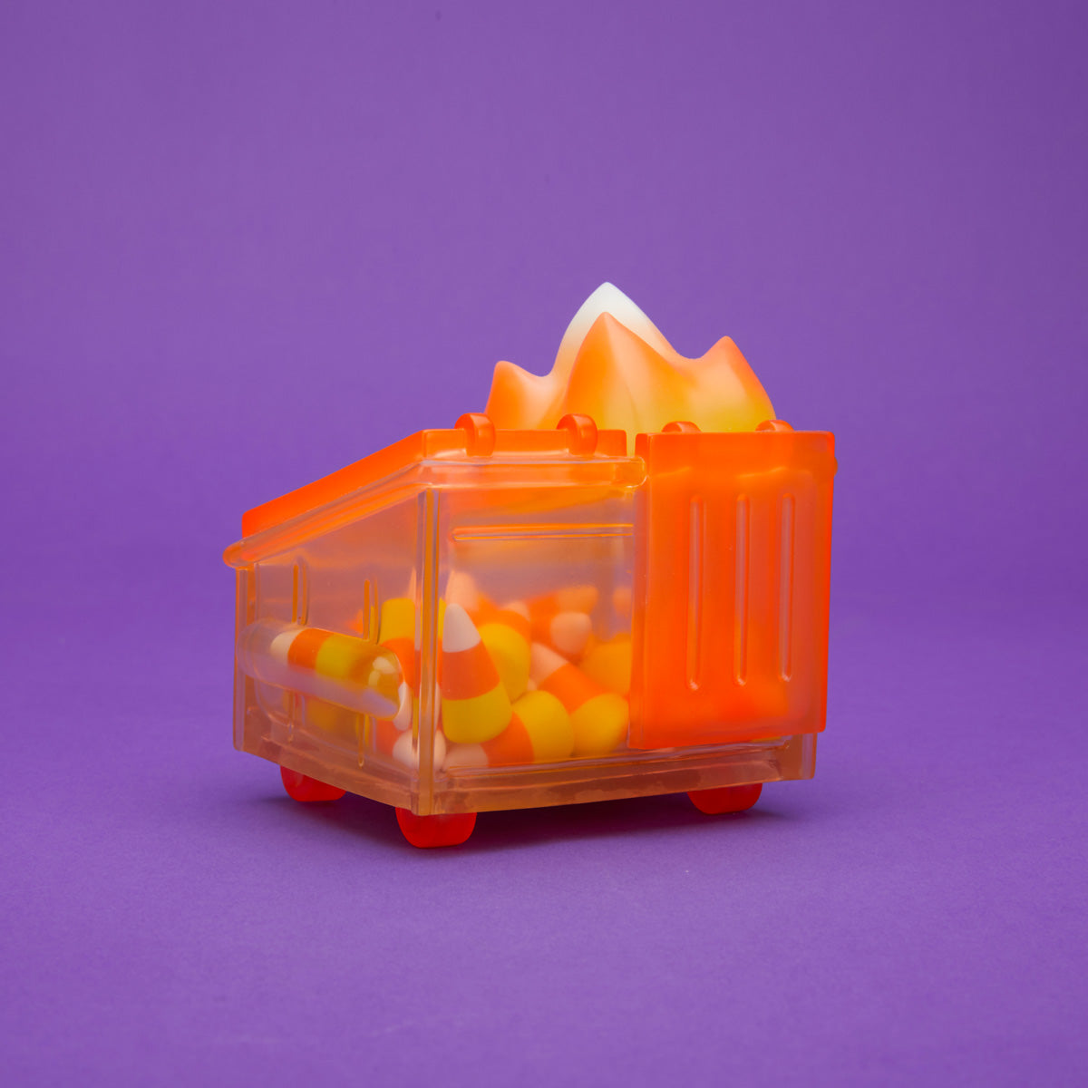 Orange translucent Dumpster Fire filled with candy corn and a yellow, orange, and white flame, pictured with its box.